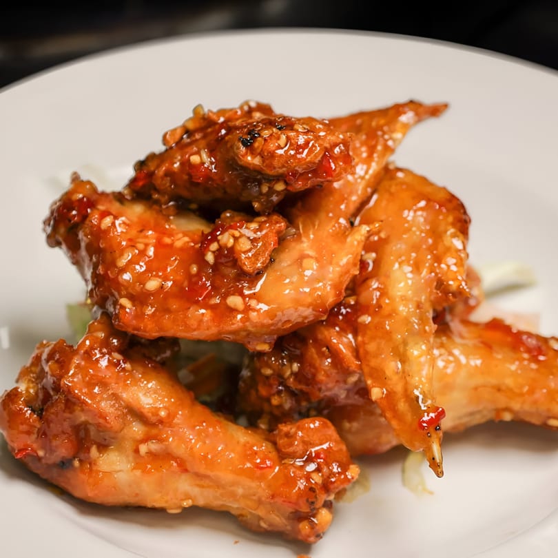 Close-up of Royal Thai and Sushi's sweet and spicy chicken wings with sesame seeds.